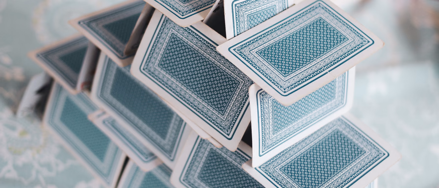 Playing cards stacked together to make a house of cards.